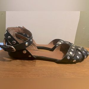 Report size 10 Winnie D black sandals with metal grommets.